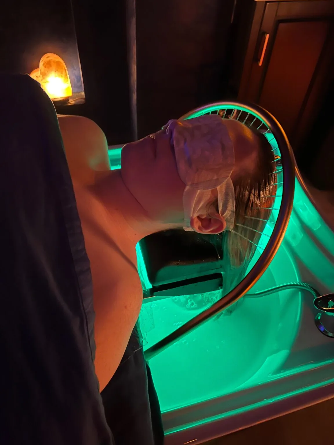 Head Spa Waterfall Therapy at Yui Spa Massage — warm flowing water, teal basin, salt-lamp glow