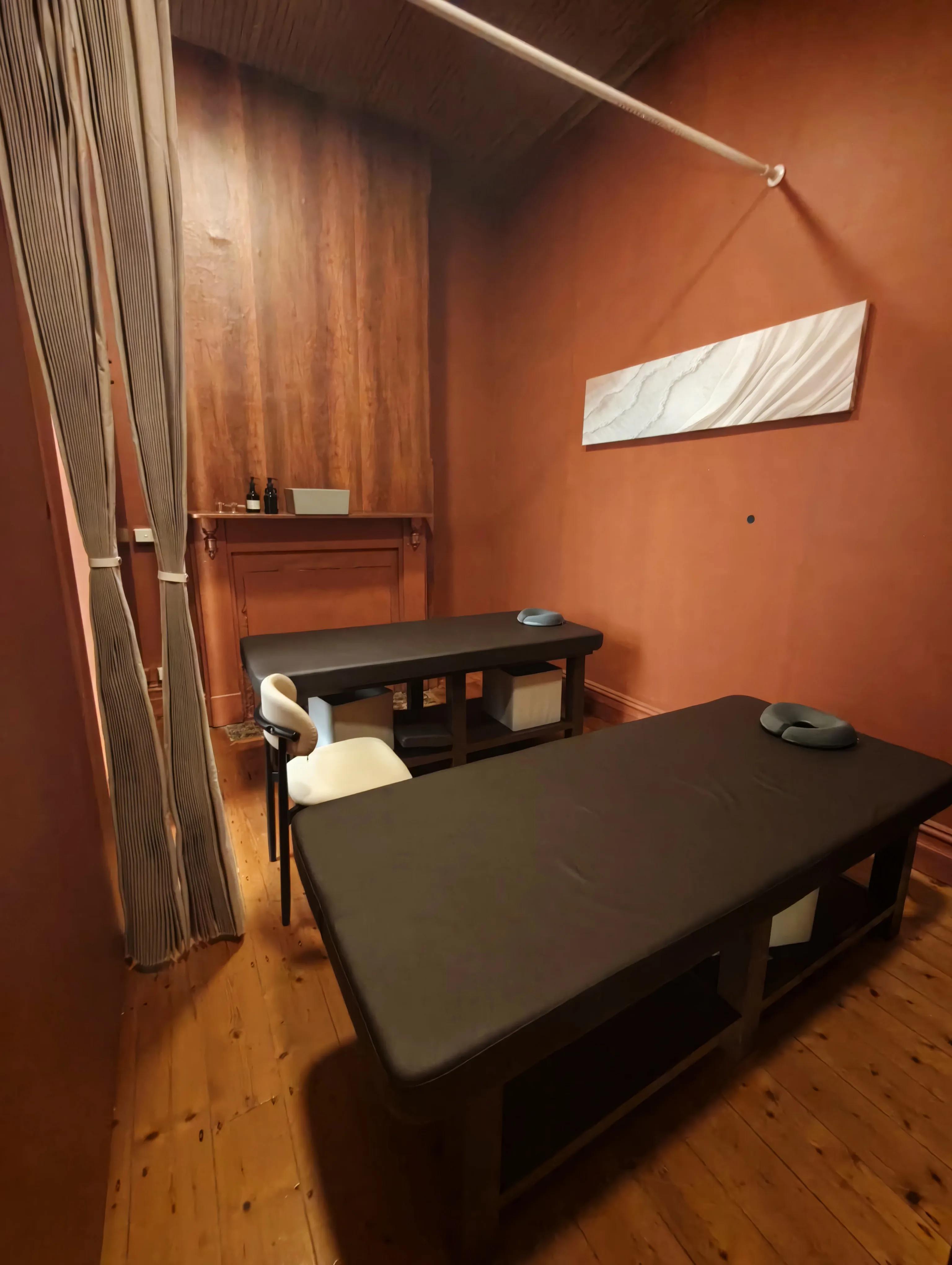 Interior of Yui Spa Massage — terracotta walls, timber floor, massage tables with warm dim light